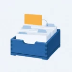 Une boîte à fiches ouverte, pleine de fiches blanches ; une fiche jaune orangé dépasse, reliée à une autre par un trait.